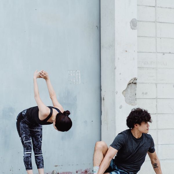 A man in a dynamic stretching pose, showing flexibility and balance.